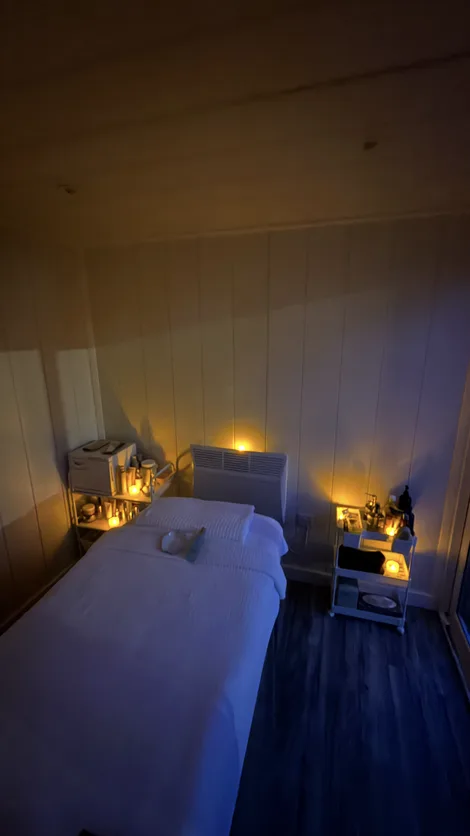The treatment room after dark, candles lit along the shelves.
