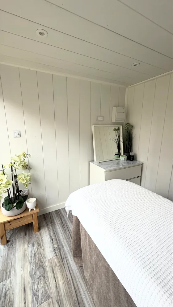 The massage table made up, sun across the panelling.
