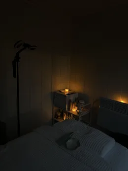 The shelf of products, lit by a candle.